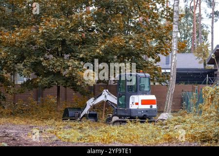 trattore con pala piccola con cingoli in cantiere Foto Stock