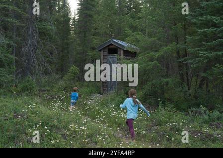 Ragazzo e ragazza corrono verso l'attico di legno nella foresta. Foto Stock