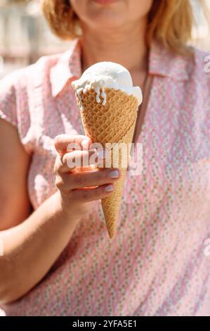 una ragazza tiene un gelato tra le mani Foto Stock