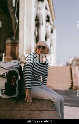 Una donna di mezza età viaggia con uno zaino Foto Stock