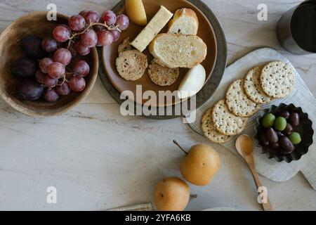 Salumi con cracker, formaggio, uva e pere su un tavolo Foto Stock
