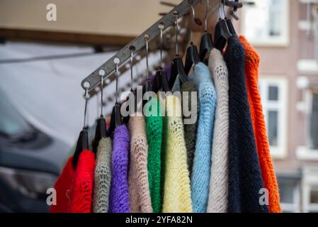 Maglioni di lana colorati appesi su grucce in vendita nel mercato all'aperto di Leida, Paesi Bassi Foto Stock