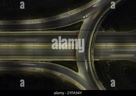 Vista dall'alto del drone aereo di una moderna rotatoria autostradale con auto in rapido movimento. Infrastrutture di trasporto, Nicosia Cipro Foto Stock