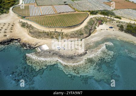 Vista aerea del drone di serre in fila, di coltivazione di ortaggi e frutta in prossimità di una costa. Coltivazione alimentare Agricoltura, prodotti biologici. Paralimni Cipro Foto Stock