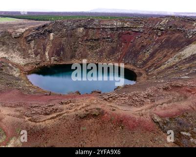 Vista aerea del lago vulcanico del cratere di Kerið, un'impressionante attrazione naturale sul percorso del cerchio d'oro dell'Islanda, caratterizzato da una vibrante roccia vulcanica rossa e marrone Foto Stock