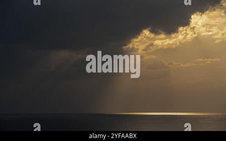 Sunrise in the sea with cloud stormy clouds and orange colour. Seascape in the morning. Sun rays in the ocean Stock Photo