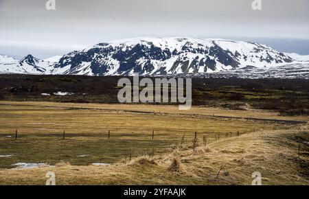 Tipico islandese drammatico paesaggio con lago ghiacciato e montagne coperte di neve in Islanda Foto Stock