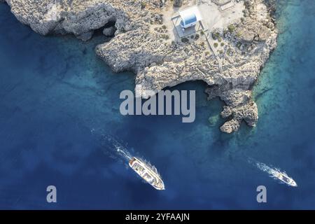 Foto aerea del drone della penisola di Capo Greko con la chiesa di Agioi Anargyroi sulle rocce. Crociera barche turistiche vela. Acque turchesi dell'oceano Foto Stock