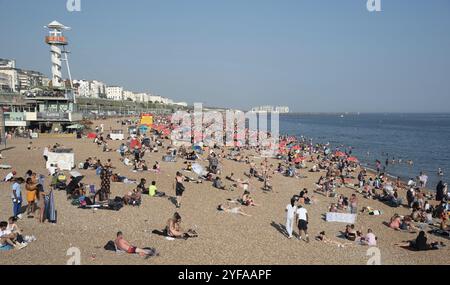 Brighton, Regno Unito, 10 giugno 2023: Folla di cittadini britannici che prendono il sole nuotano e si rilassano in spiaggia in estate. Tempo libero all'aperto, Europa Foto Stock