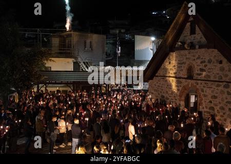 Nicosia, Cipro, 23 aprile 2022: Folla di religiosi che tengono candele e pregano fuori dalla chiesa cristiana durante la celebrazione della Santa Pasqua ortodossa Foto Stock