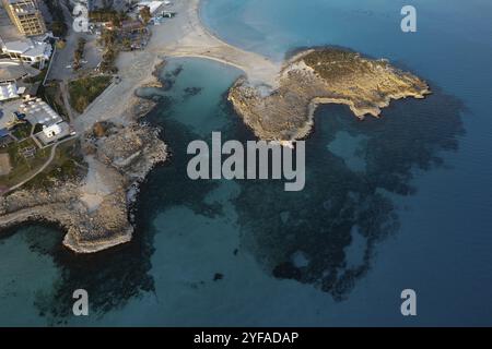 Vista aerea in droni della costa di una spiaggia vuota in inverno. Vacanze estive. Nissi Beach Bay Ayia Napa, Cipro, Europa Foto Stock