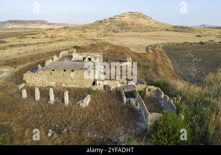 Vista aerea dell'edificio di un allevamento di animali abbandonato e in caduta sul campo. Luoghi deserti Cipro Foto Stock