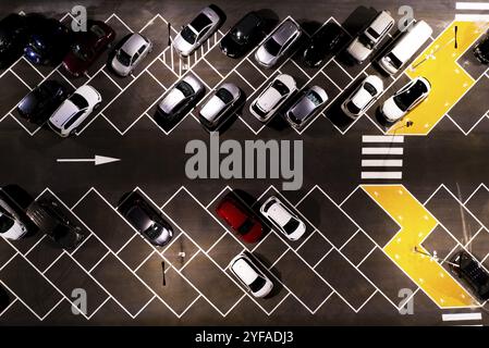 Vista aerea dei parcheggi con auto durante la notte. Affollato centro commerciale, parcheggio all'aperto Foto Stock