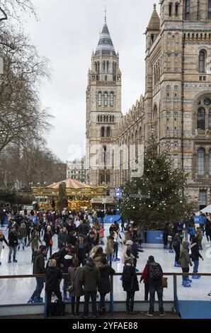 Londra, Regno Unito, 12 dicembre 2015: Persone che si divertono a pattinare sul ghiaccio e altri giochi durante le celebrazioni natalizie fuori dal museo di storia naturale di Londra Foto Stock