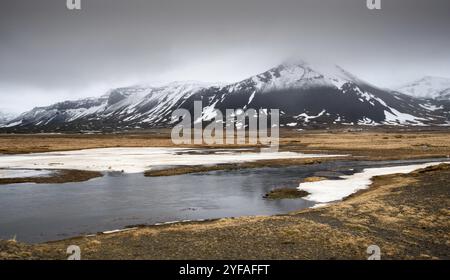 Tipico islandese drammatico paesaggio con lago ghiacciato e montagne coperte di neve in Islanda Foto Stock