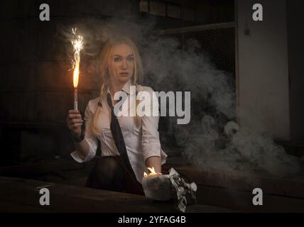 Donna che tiene bastone fuoco bruciante. Fuoco fumo tossico pericoloso e fiamme Foto Stock