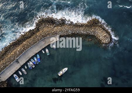 Vista aerea con droni delle barche da pesca ormeggiate al porto a Break Water. Onde tempestose in mare Peyia, Cipro, Europa Foto Stock