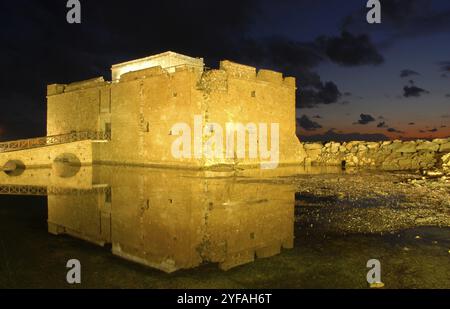 Famoso castello medievale di Paphos vicino al porto di pescatori della città di Paphos che si riflette sull'acqua Foto Stock