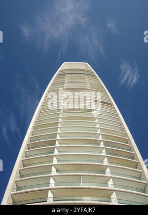 Edificio moderno con dettagli contro il cielo nuvoloso blu. Torre bianca di lusso con architettura futuristica, immobili di lusso Foto Stock