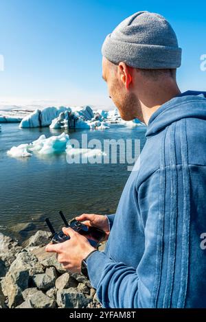 Pilota di droni che cattura le viste aeree della splendida laguna glaciale dell'Islanda in una giornata di sole Foto Stock