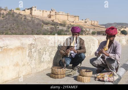 Jaipur, India? 17 marzo 2017: Incantatori di serpenti seduti e suonando musica per la dimostrazione della danza cobra fuori dal famoso forte Amer a Jaipur, in India Foto Stock