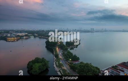 Lo skyline di Hanoi, la capitale del Vietnam e il lago Hoan Kiem durante un tramonto colorato Foto Stock