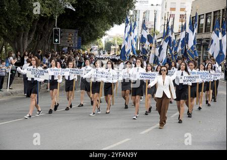 Nicosia, Cipro, 28 ottobre 2015: Studentesse con le loro uniformi scolastiche che detengono bandiere e posti greci con nomi di villaggi ciprioti che sfilano durante Foto Stock