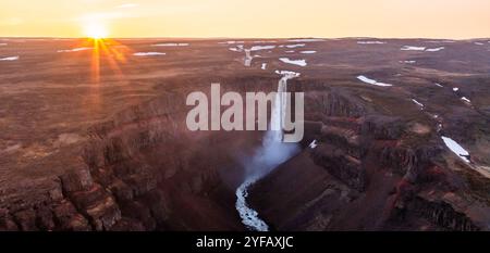 Splendida vista al tramonto di una maestosa cascata che si getta in un profondo canyon, creando una scena mozzafiato di bellezza naturale in Islanda. Foto Stock