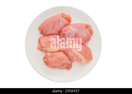 Cosce di pollo disossate nel piatto. Isolato su sfondo bianco. Carne di pollo cruda per cucinare. Cucinare il cibo a casa. Vista dall'alto. Foto Stock