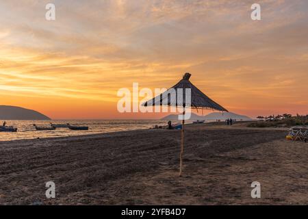 Bellissimo tramonto a Valona in Albania con un cielo colorato e scenografico e ombrelloni. Foto di viaggio, Copia spazio. Foto Stock