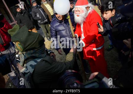 Srinagar, Kashmir. 25 dicembre 2019. I cristiani celebrano il Natale fuori dalla Chiesa cattolica della Sacra famiglia a Srinagar, nel Kashmir amministrato dall'India. La chiesa della Sacra famiglia fu fondata nel 1896, durante l'era coloniale britannica Foto Stock