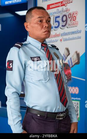Guardia di sicurezza in servizio davanti alla porta della banca. Guardia di sicurezza all'ingresso della banca Phuket Thailandia. Una guardia in uniforme al Foto Stock