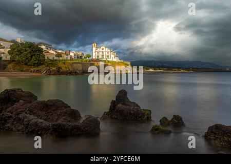 Vista sulla Praia de São Roque verso la chiesa di São Roque al tramonto. Foto Stock