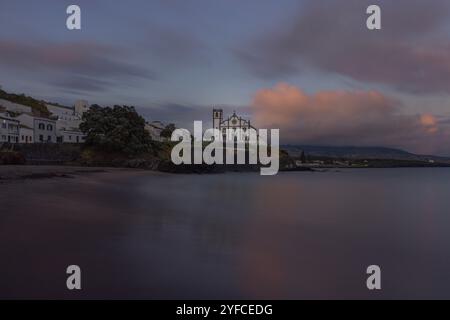 Vista sulla Praia de São Roque verso la chiesa di São Roque al tramonto. Foto Stock