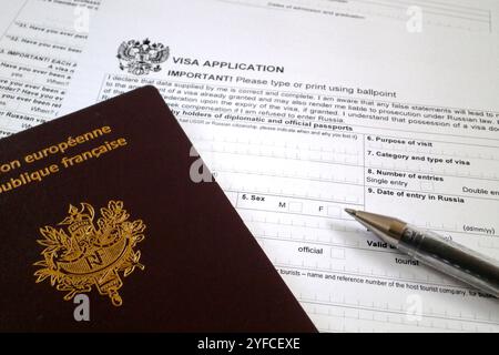 Una penna a sfera e un passaporto francese sulla parte superiore del modulo di domanda di visto per la Russia. Foto Stock