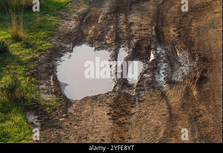 Fango con piste per veicoli su una strada rurale dopo una pioggia intensa, Spagna. Foto Stock