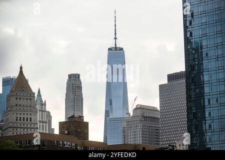 Una vista del One World Trade Center di New York City, circondato da un mix di moderni grattacieli di vetro ed edifici storici sotto un cielo coperto. Foto Stock
