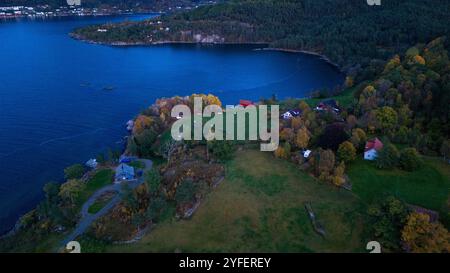 Vista aerea di un paesaggio costiero con case, alberi e una baia. Foto Stock