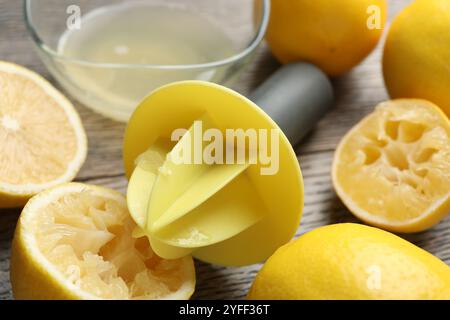 Centrifuga in plastica e limoni freschi su tavolo in legno grigio, primo piano Foto Stock