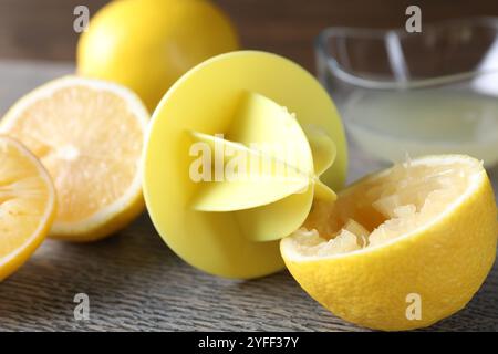 Centrifuga in plastica e limoni freschi su tavolo in legno grigio, primo piano Foto Stock