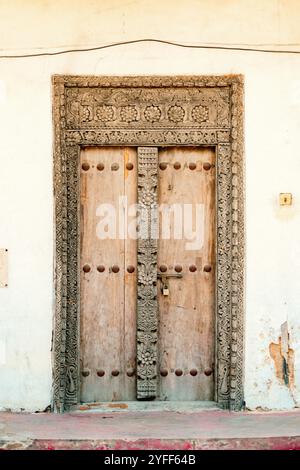 Una porta Swahili o Zanzibar all'ingresso del vecchio forte - un edificio storico abbandonato nella città vecchia di pietra, Bagamoyo, Tanzania Foto Stock
