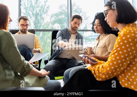 Diversi team di manager stanno organizzando riunioni produttive, collaborando e pianificando strategie su un progetto in un ufficio moderno Foto Stock