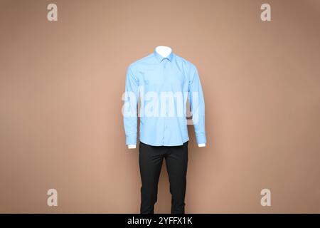 Manichino maschile con elegante camicia e pantaloni su sfondo marrone chiaro Foto Stock