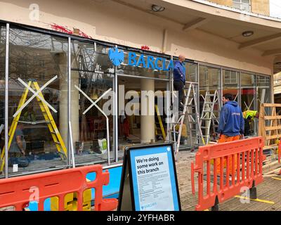 Lavori di riparazione in corso della Barclays Bank a Bristol, che è stata attaccata dagli attivisti dell'azione palestinese, che hanno distrutto il vetro e spruzzato vernice rossa. Foto Stock