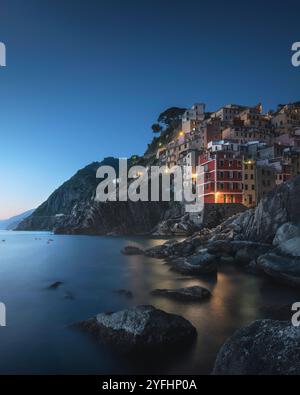 Crepuscolo blu sul villaggio di pescatori di Riomaggiore. Paesaggio marino nel Parco Nazionale delle cinque Terre, provincia di la Spezia, regione Liguria, Italia, Europa. Foto Stock