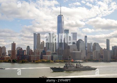 New York, Stati Uniti. 4 novembre 2024. Il cacciatorpediniere missilistico guidato classe Arleigh Burke USS John Basilone della Marina degli Stati Uniti passa lo skyline di Manhattan sulla strada per il molo 88 per essere nominato la nuova nave della marina, il 4 novembre 2024 a New York City, New York. Crediti: EJ Hersom/DOD Photo/Alamy Live News Foto Stock