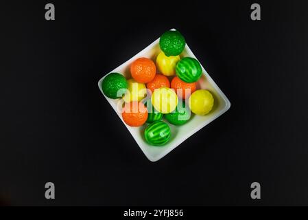 Palle di gomma da masticare di diversi colori in contenitori lucidi in terracotta con uno sfondo colorato omogeneo per il posizionamento del testo Foto Stock