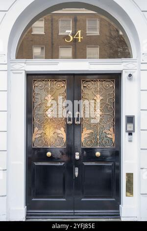 Porta in legno nero decorata con vetro e metallo, primo piano Foto Stock