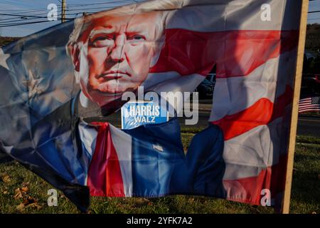 Un cartello della campagna Harris-Walz è visto attraverso una bandiera Trump ondeggiante il 4 novembre 2024, su Emmaus Avenue ad Allentown, Pennsylvania. Foto Stock