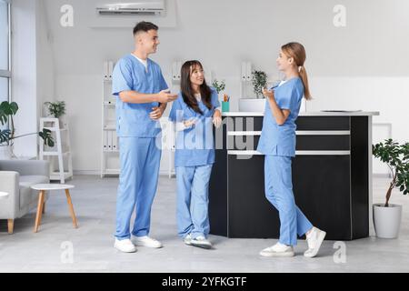 Gli stagisti medici parlano vicino alla reception in clinica Foto Stock